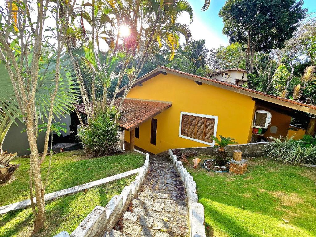 una piccola casa gialla con un cortile e un orto di Top Houses Casa Serena em Arraial d'Ajuda a Arraial d'Ajuda