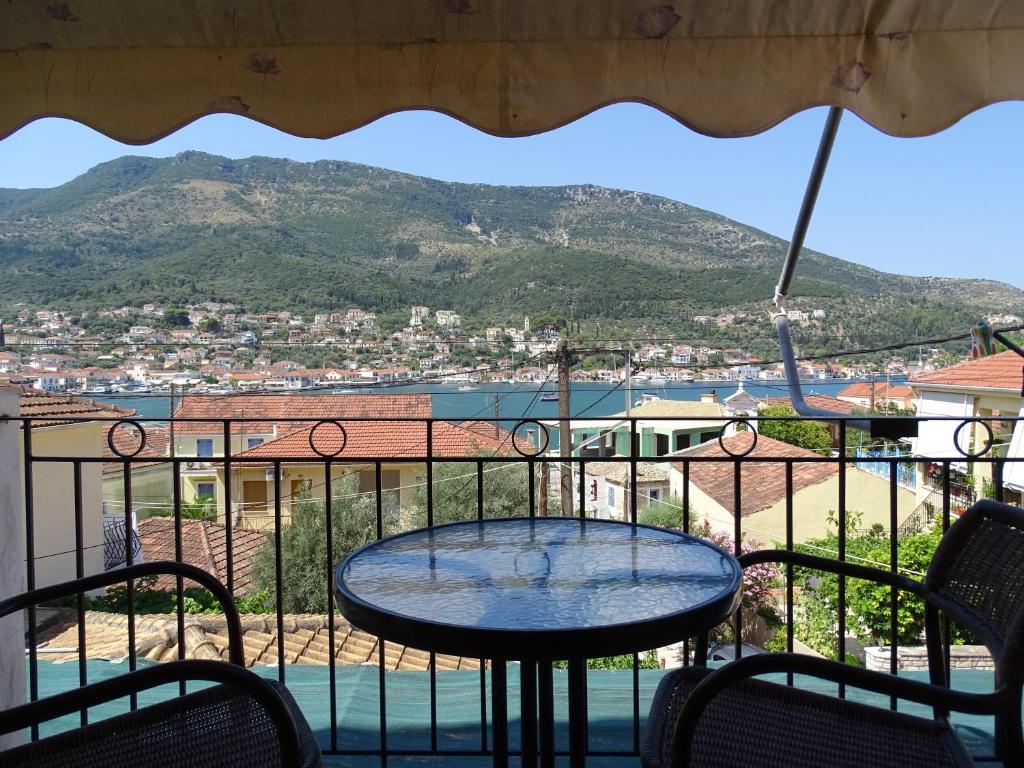 a table on a balcony with a view of a mountain at Maroudas Stavros Apartments in Vathi