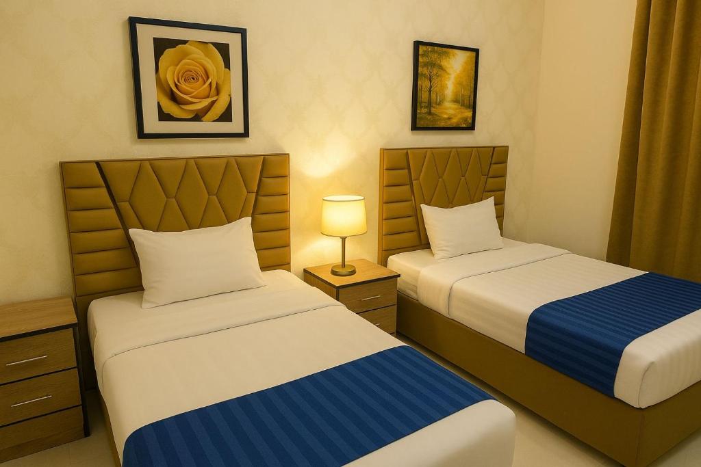 a bedroom with two beds and a lamp at فندق الشموخ in Abha