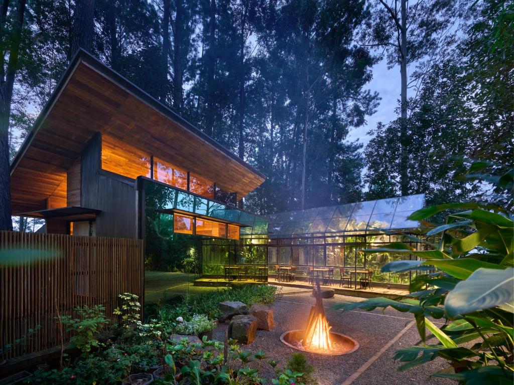 a house with a fire pit in the middle of a garden at Kaya Retreats - Diyathalawa in Ellealutwela
