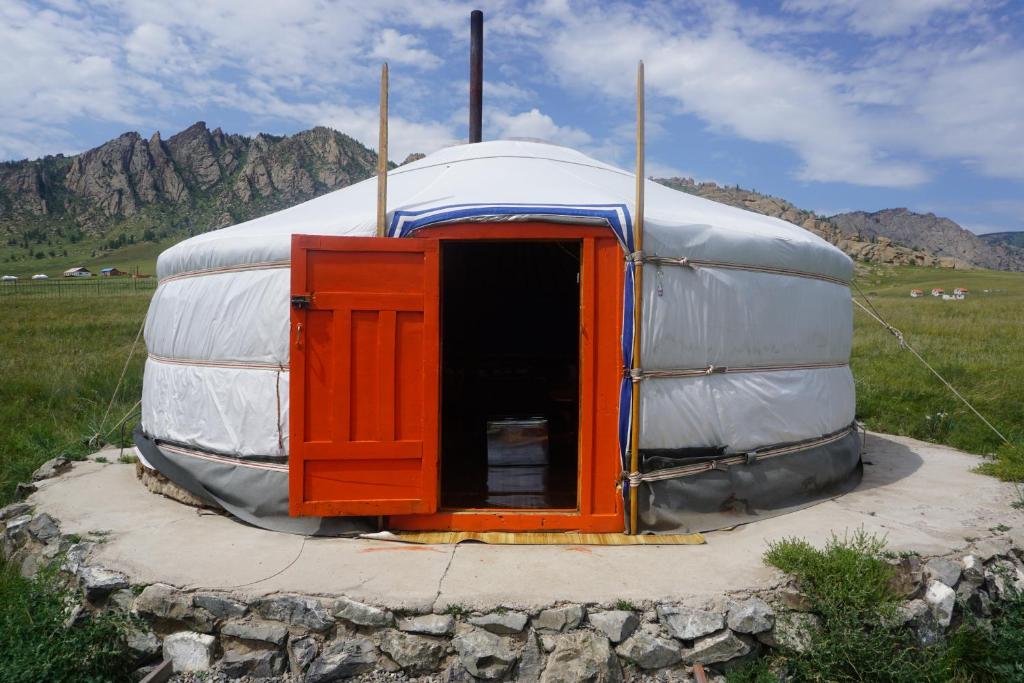 a large dome tent with a door in a field at My Mongolia Eco Ger Camp in Nalayh