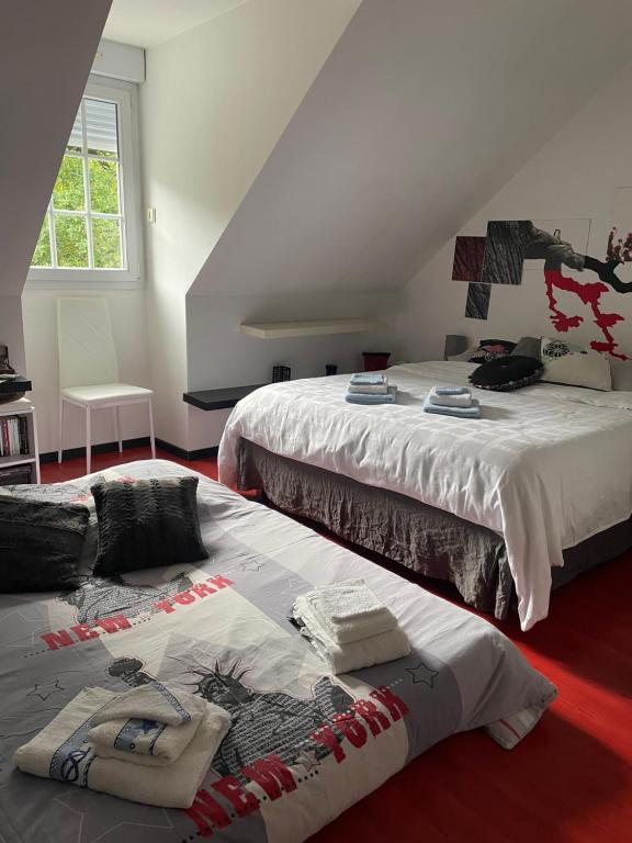a bedroom with two beds with towels on the floor at Chambres dans maison avec piscine toboggan aquatique et spa in Saint-Mars-la-Brière
