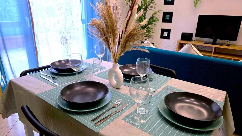 トリノにあるOlympic Hidden Houseの黒皿とワイングラスが付いたテーブル