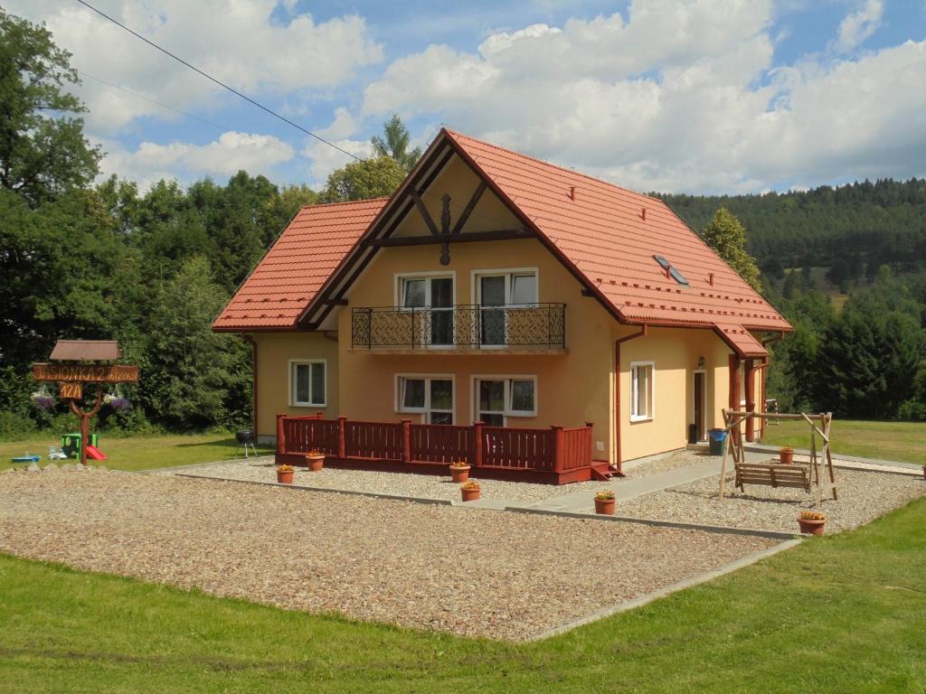 mały domek z czerwonym dachem i placem zabaw w obiekcie Jasionka 2 w mieście Ustrzyki Dolne