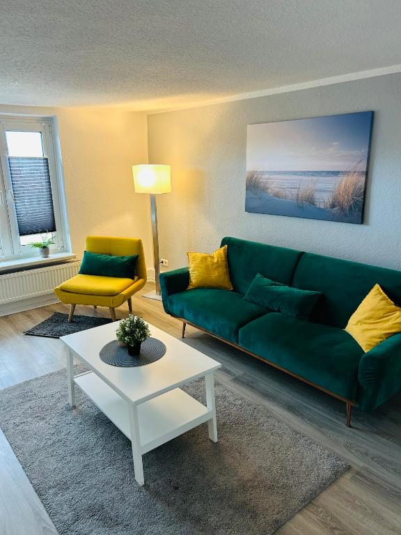 a living room with a green couch and a table at Blaue 8 -2 in Leezen
