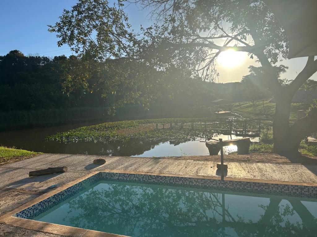 een zwembad voor een vijver met de zonsondergang bij Lago da Rosa in Olímpia