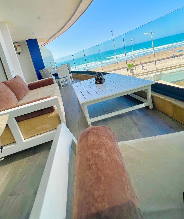 a living room with a table and a view of the beach at Mehdia's Paradise in Kenitra