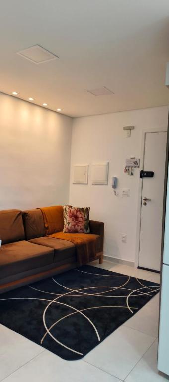a living room with a brown couch and a rug at Apartamento na praia in Itapema