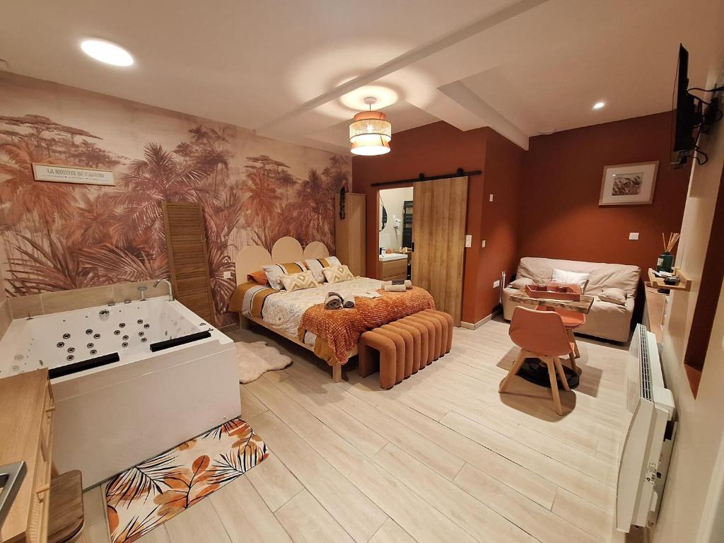 a large room with a bed and a bathroom at La Cour d'Hortense in Sailly-Flibeaucourt