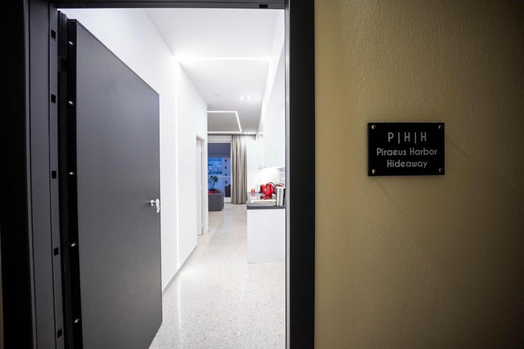 a hallway leading to a kitchen with a sign on a wall at Piraeus Harbor Hideaway in Piraeus
