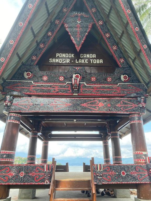 a pavilion with a table and a bench in it at Pondok Ganda in Ambarita