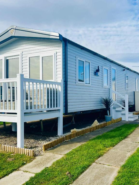 a blue house with a porch and a yard at Haven Berwick in Berwick-Upon-Tweed