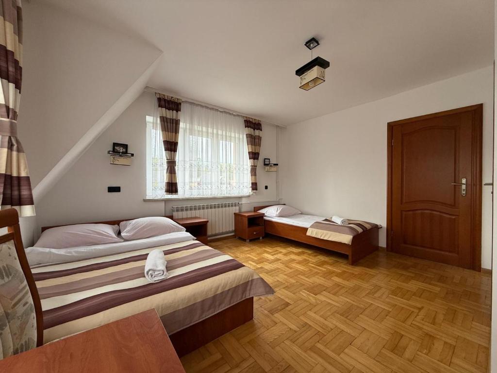 una camera da letto con due letti e una finestra di Pokoje W Górach Savanna a Biały Dunajec