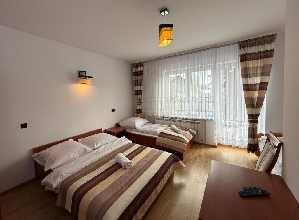 een hotelkamer met twee bedden en een tafel bij Pokoje W Górach Savanna in Biały Dunajec