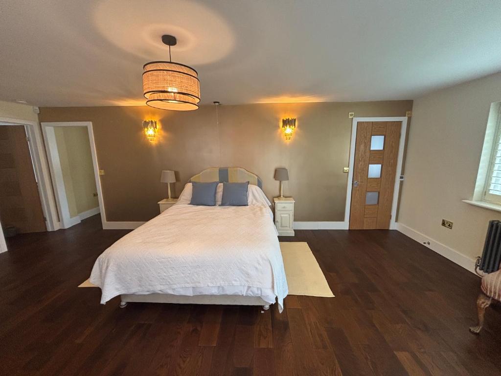 a bedroom with a large white bed with blue pillows at Boycott House in Shalstone
