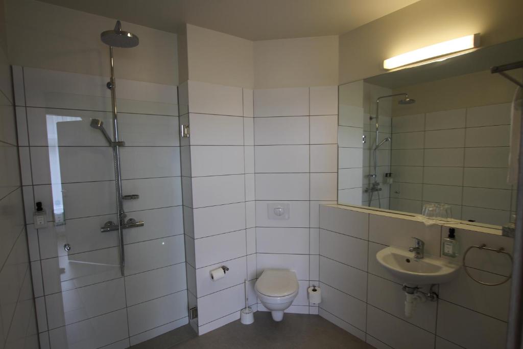 a bathroom with a shower and a toilet and a sink at Hotel Hallormsstadur in Hallormsstaður