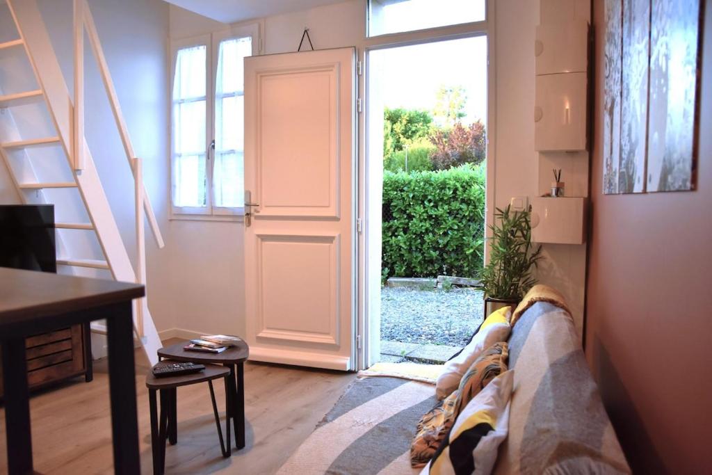 a living room with a couch and an open door at Studio Castéra 1 Air-conditioned in Bègles