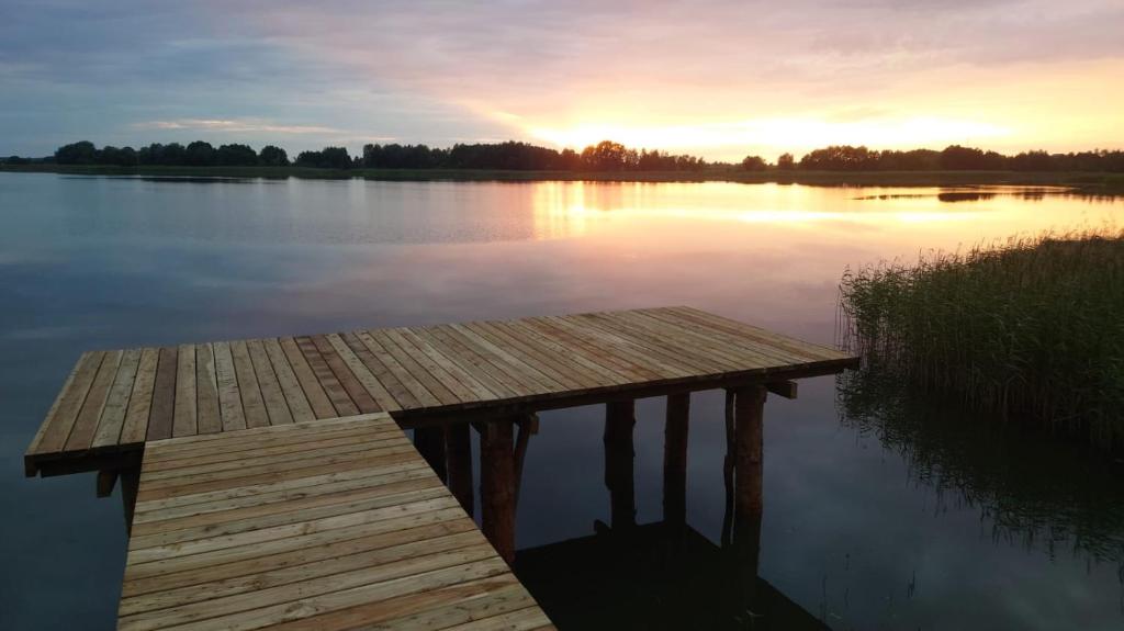 RybczyznaChata Chochlika的日落时分在湖上的一个木船坞