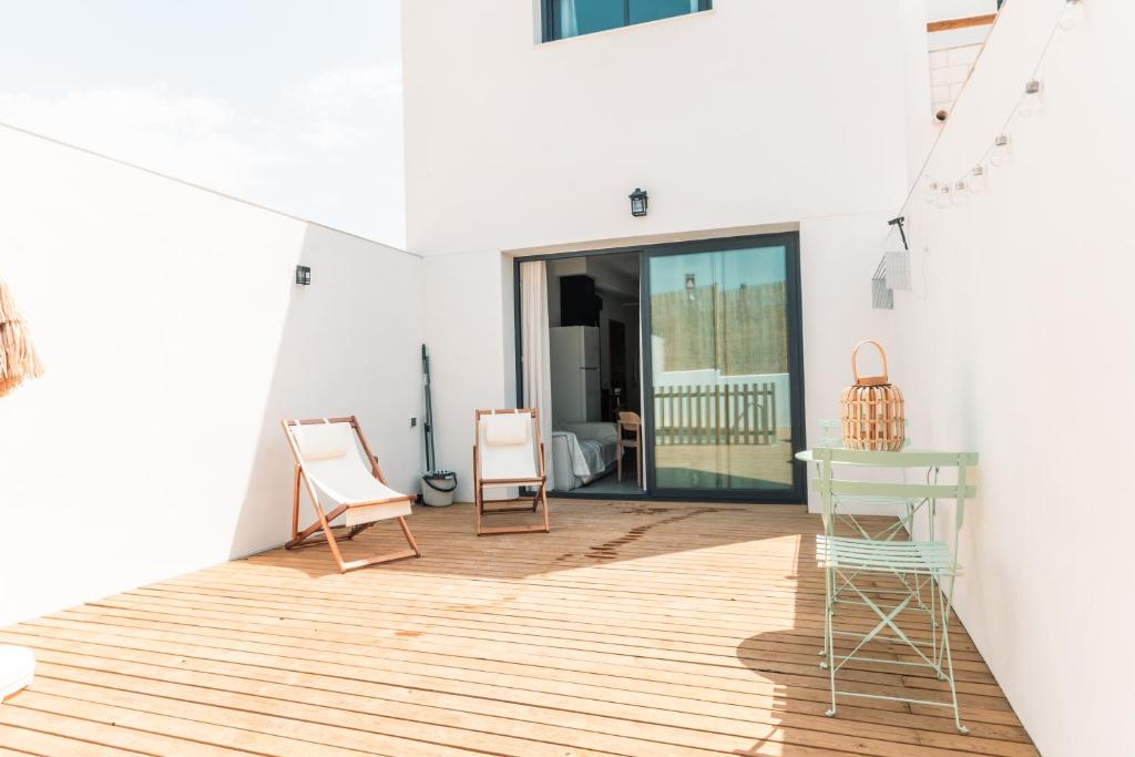 a room with two chairs and a desk on a wooden floor at Villa sunset piscina privada in Luque