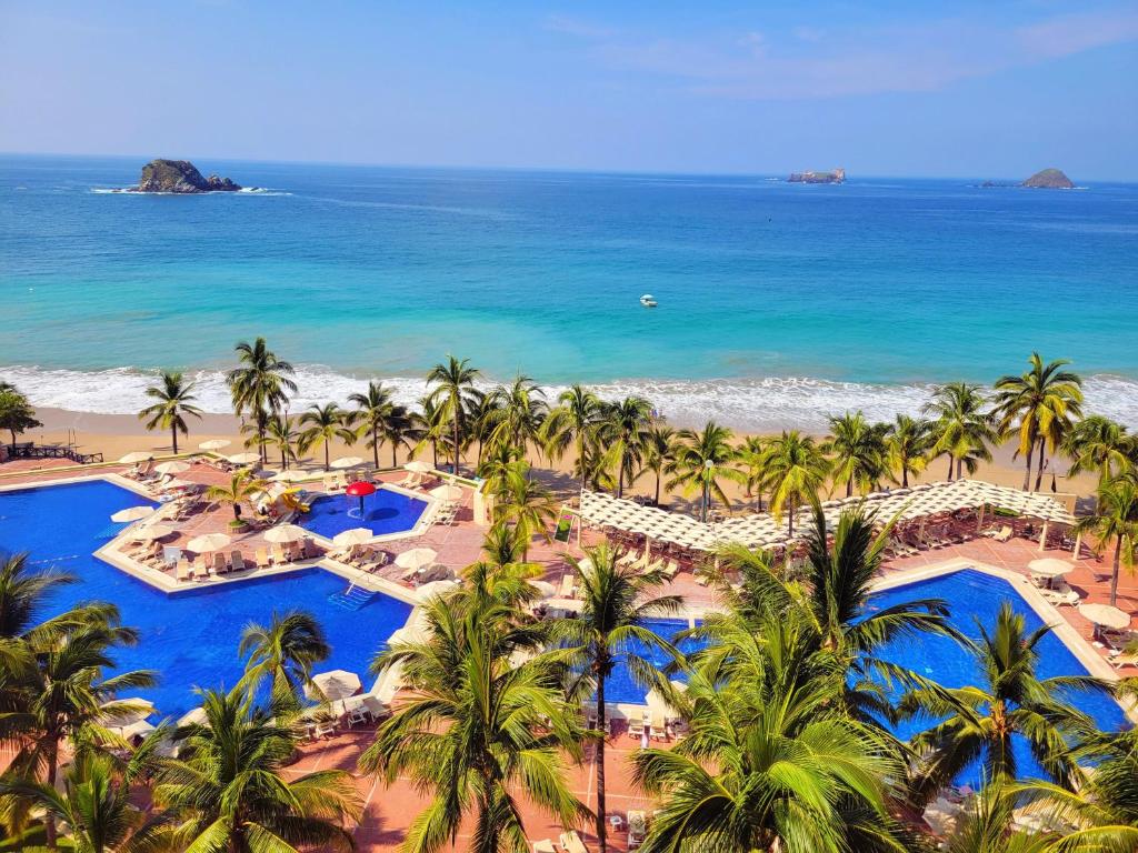 Una vista aérea de un resort con palmeras y el océano. en Barceló Ixtapa - All Inclusive, en Ixtapa
