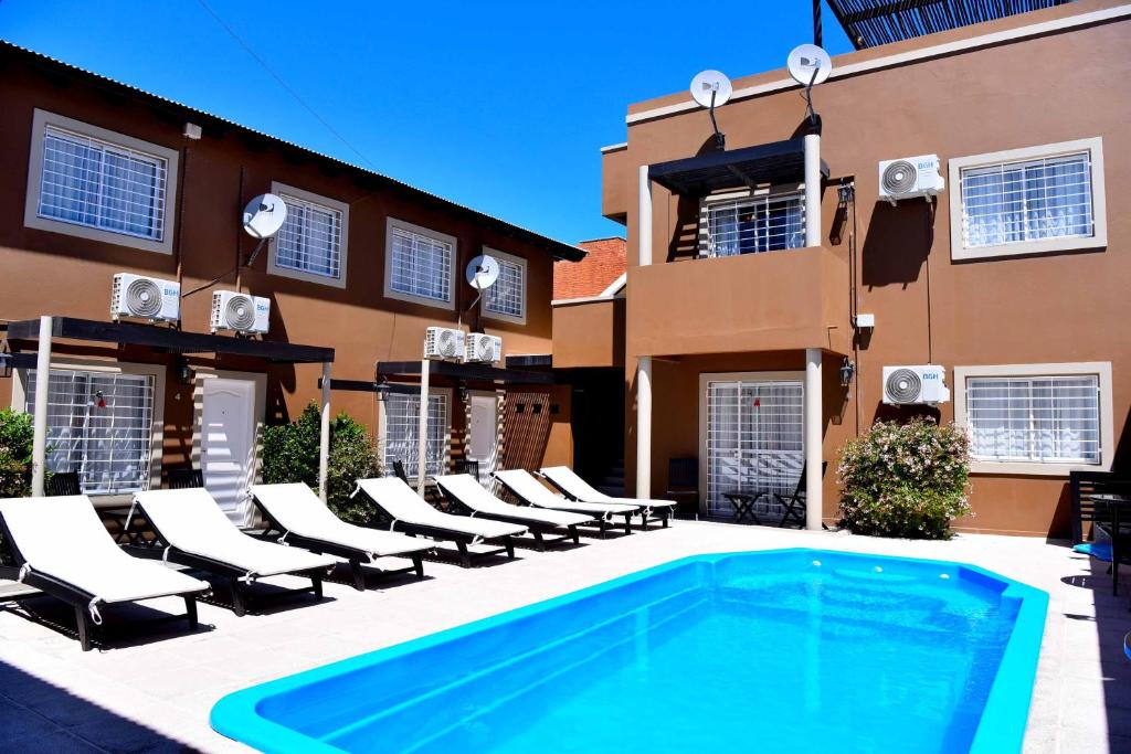 a swimming pool in front of a building at Complejo Pircas Mar in Las Grutas