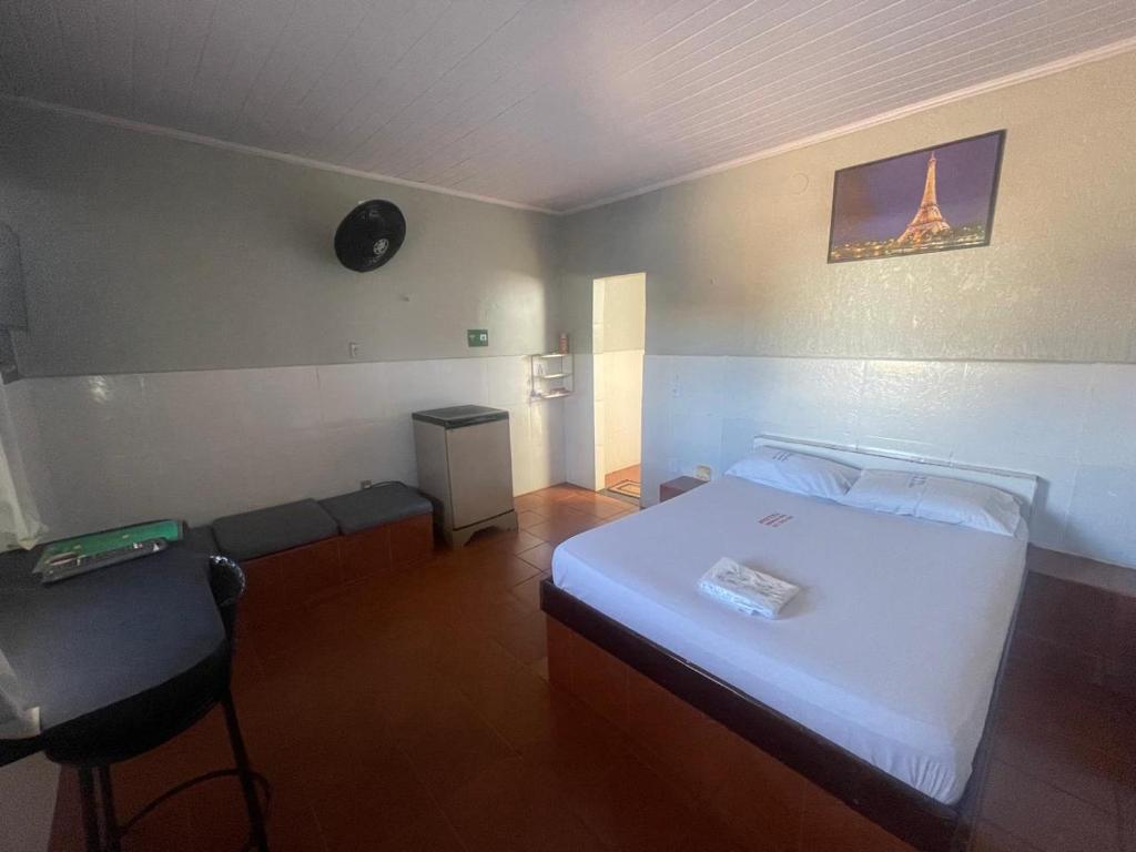 a bedroom with a white bed and a couch at Hotel Morada da Serra in Macacos
