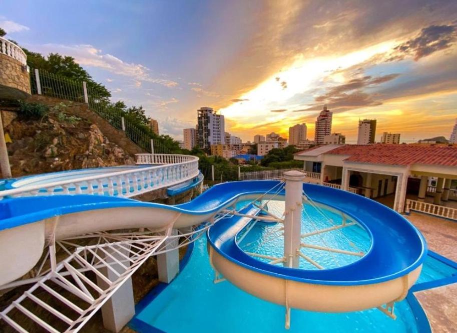 Un tobogán de agua en un crucero con una ciudad al fondo. en casa fresh, en Rodadero