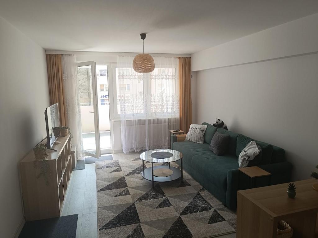 a living room with a green couch and a table at 2-room apartment, central & quiet in Gdynia