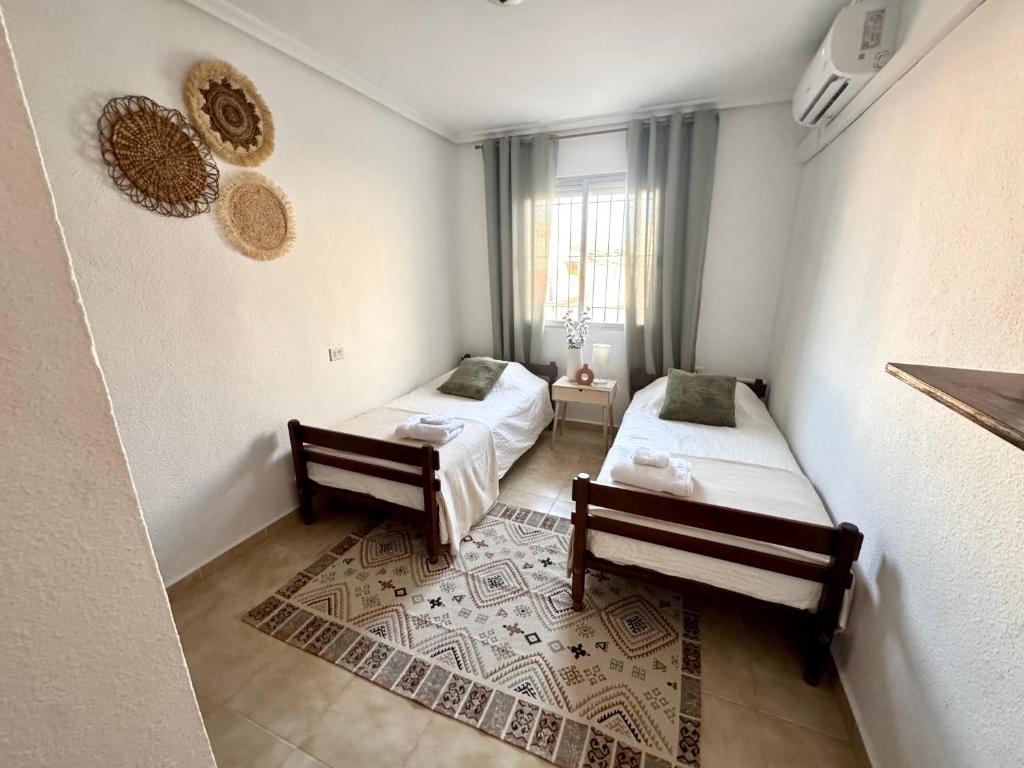 a room with two beds and a window at Casa Margarita in San Pedro del Pinatar
