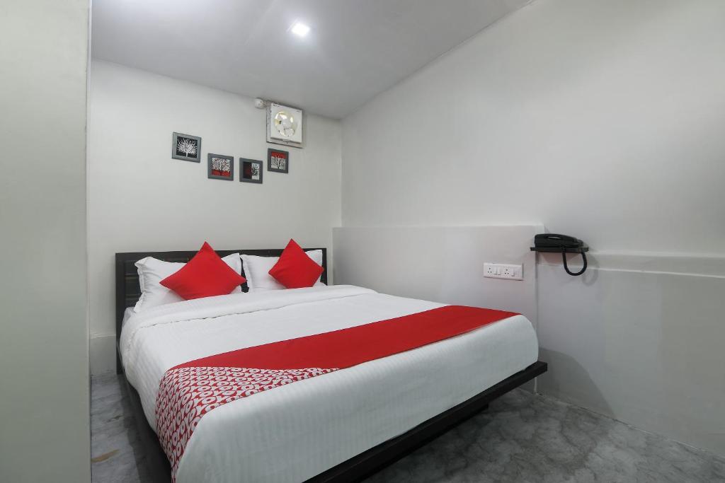 a bedroom with a large bed with red pillows at Collection O Police Bazar Shillong Formerly Pillars House in Shillong