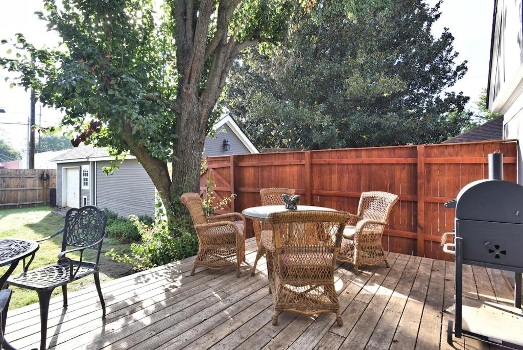een terras met een tafel, stoelen en een hek bij The Christmas Tree House in Tulsa
