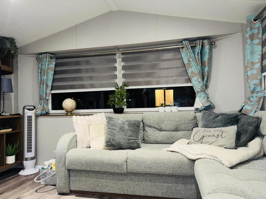 a living room with a couch and a window at Vinchella-3 bedroom caravan in Grange Over Sands