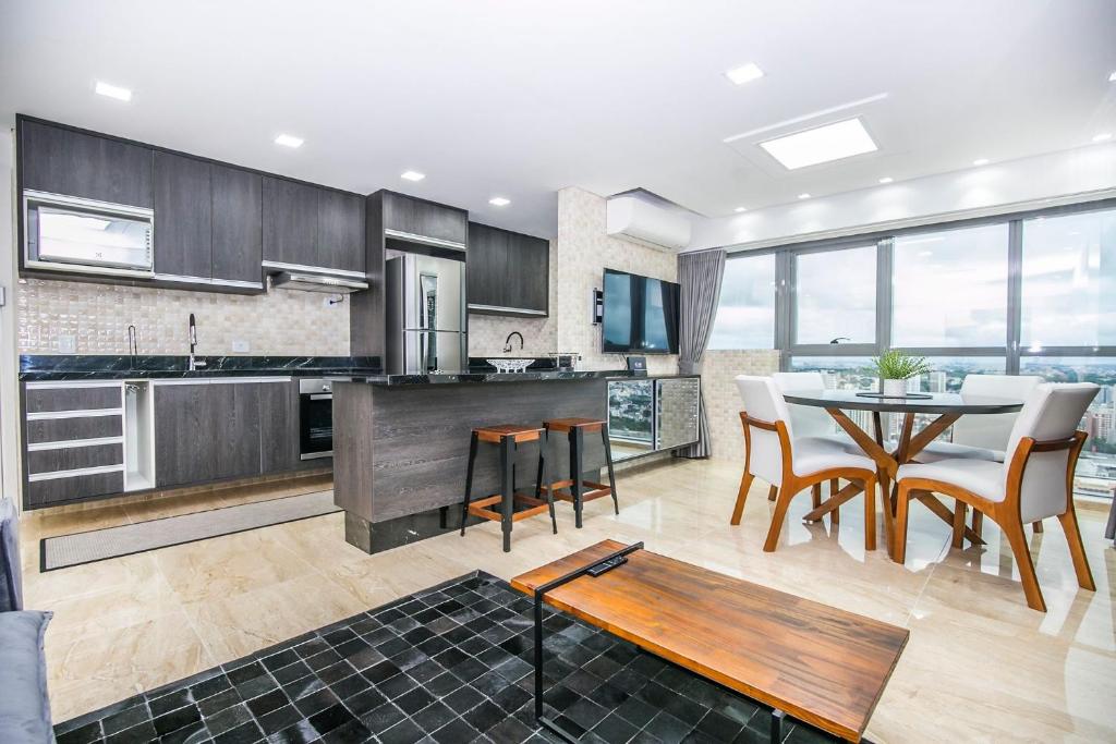 a kitchen and dining room with a table and chairs at Apto de 2 Quartos no 35 andar c 2 Vagas - SEV3507 in Curitiba