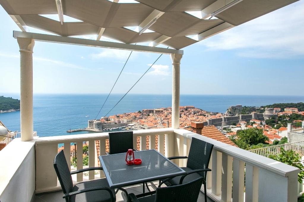 uma varanda com mesa e cadeiras e o oceano em Apartment Ivy em Dubrovnik