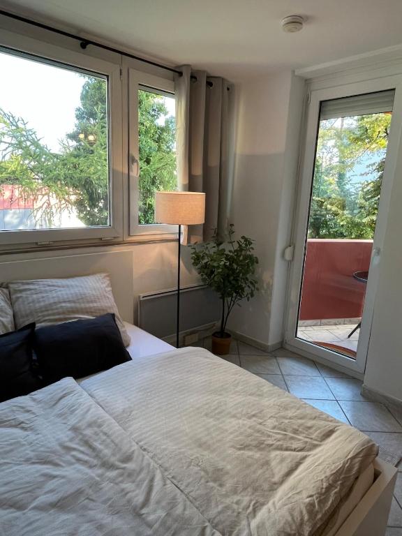 a bedroom with a bed and two large windows at SEEnah Ferienwohnung in Überlingen