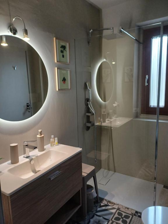 a bathroom with a sink and a shower and a mirror at A due passi dal mare in Cannigione
