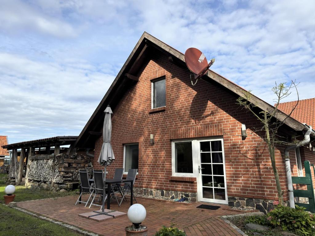 a brick house with a table and chairs on a patio at Ferienhaus in Neu Poserin for 5 Personen in Neu Poserin