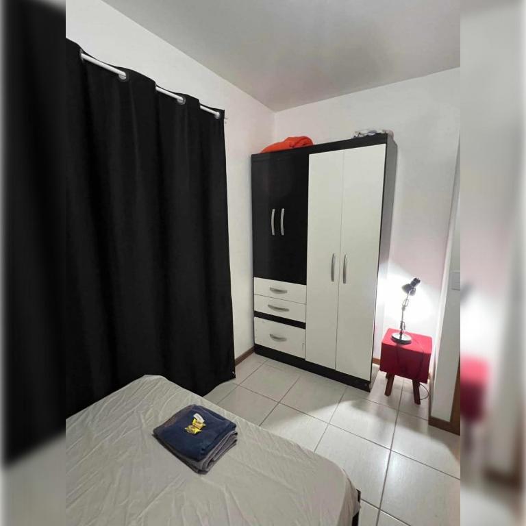 a bedroom with a bed and a cabinet and a red table at Hotel Tejas Verdes in Villa Gesell