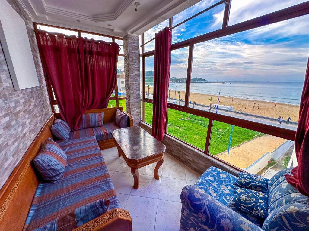 a living room with a view of the beach at Étoile de la mer in Ksar es Sghir