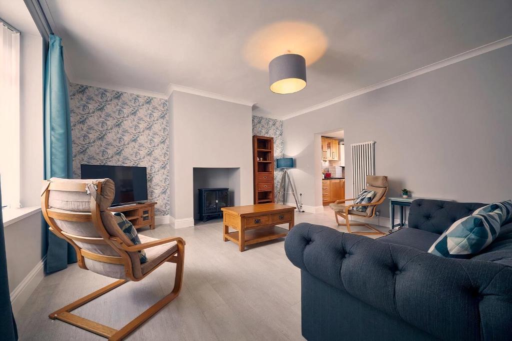 a living room with a couch and a tv at Roselyn By The Sea - Pet Friendly Accommodation in Newbiggin-by-the-Sea