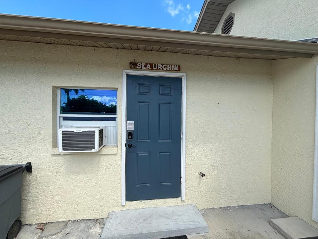 a house with a blue door and a window at Sea Urchin - Amazing Private Suite Large Bath 3.3mi 2 Beach in Bonita Springs