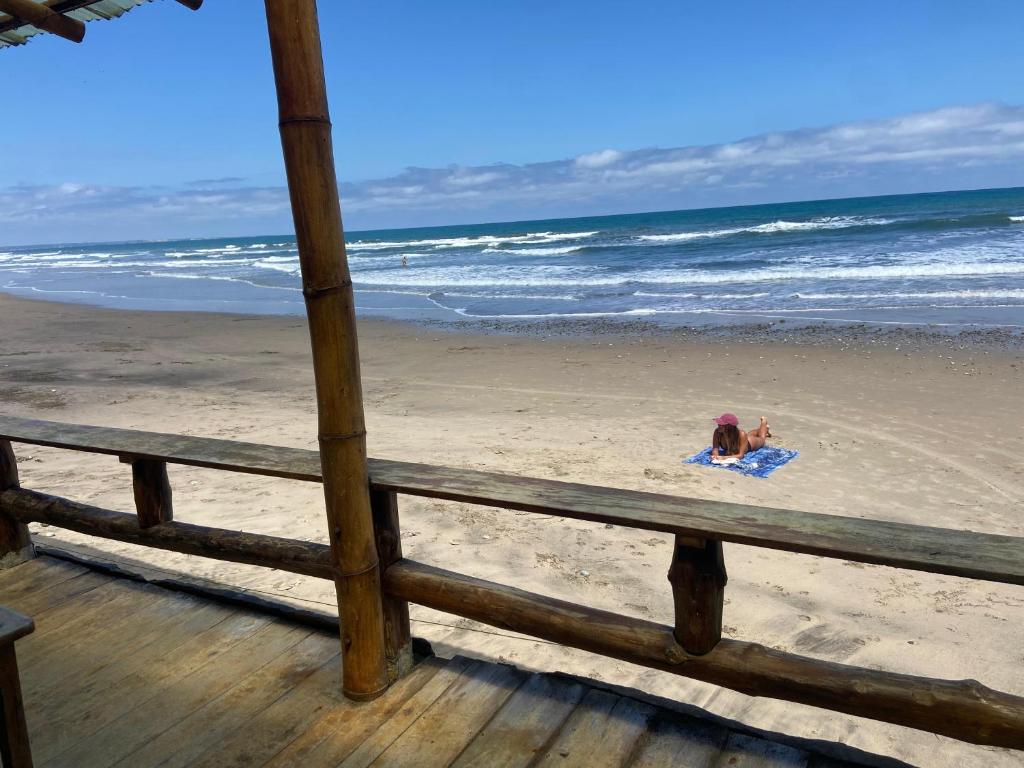 Dos niños tumbados sobre una toalla en la playa en Hostal Rosa Mística, en Montañita