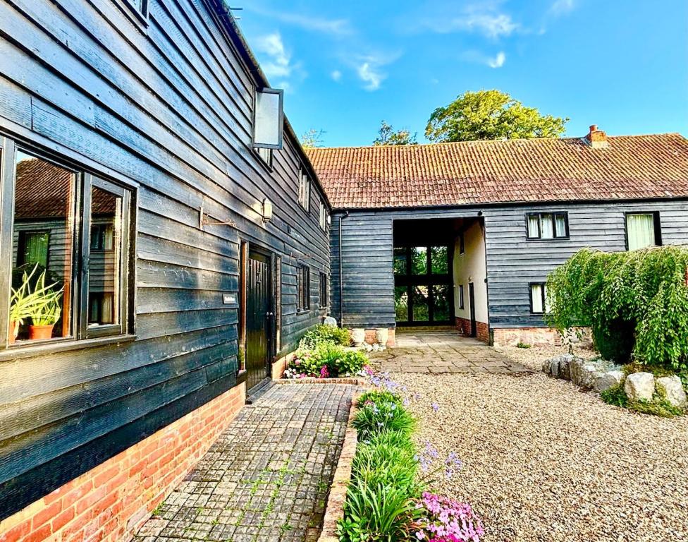a house with a brick walkway next to a building at The Swallows Rest, Avebury in Avebury