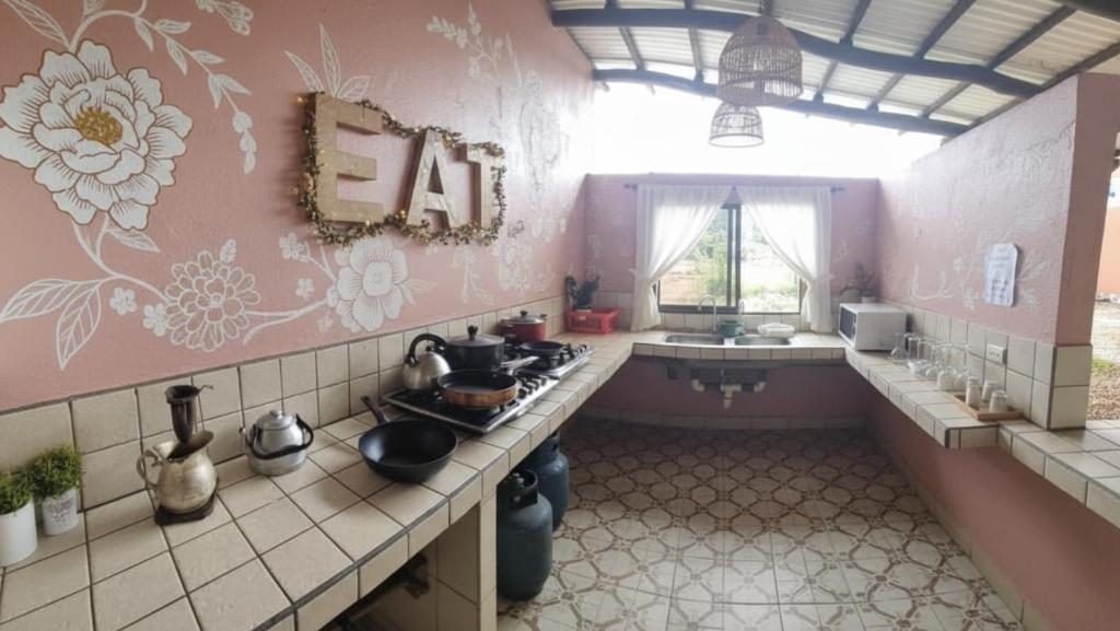 a kitchen with a stove and a sink in it at Her Waves & Wi-Fi Boutique Hotel in Tamarindo