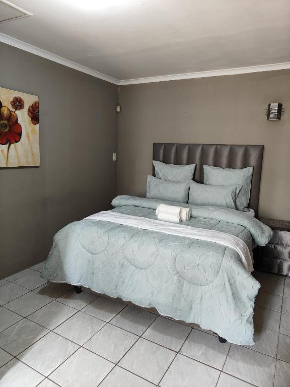 a bedroom with a large bed with a blue comforter at Tranquil Leisure in Midrand