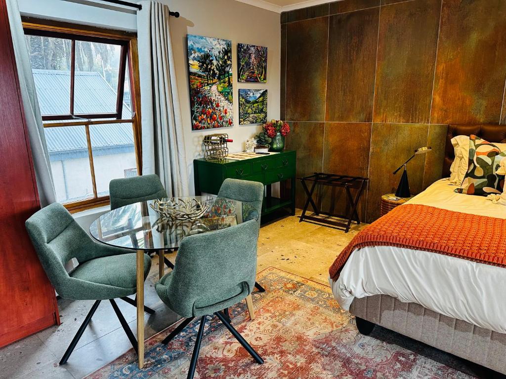 a bedroom with a table and chairs and a bed at Rest in the Village in Wilderness