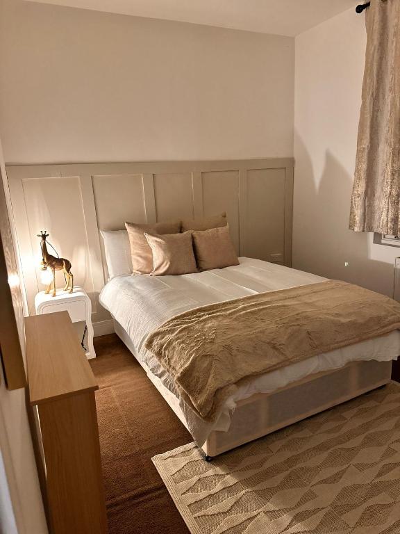 a bedroom with a large bed and a table at Sky High Apartment in Streatham in London