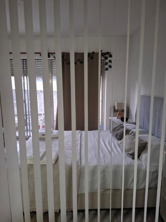 a white crib in a bedroom with a bed at Céntrico Amplio Luminoso in Rosario