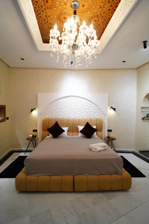 a bedroom with a large bed with a chandelier at Le 146 - Art of Living in Rabat