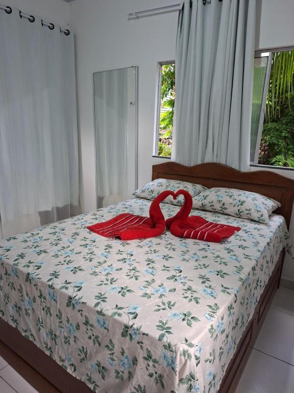two red swans are sitting on a bed at Suíte privada com TV e Wifi ambiente acolhedor in Belém